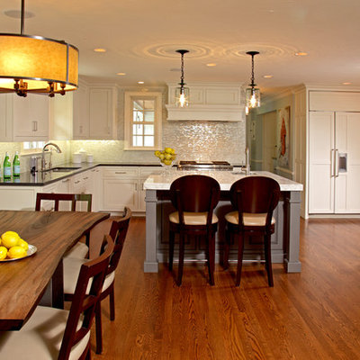 Elegant l-shaped medium tone wood floor eat-in kitchen photo in Minneapolis with marble countertops, white backsplash, paneled appliances, recessed-panel cabinets, white cabinets, a double-bowl sink and an island