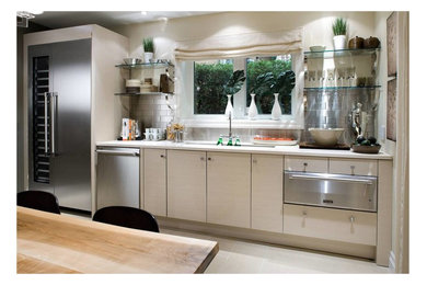 Imagen de cocina contemporánea de tamaño medio con salpicadero metalizado, salpicadero de metal, electrodomésticos de acero inoxidable y una isla