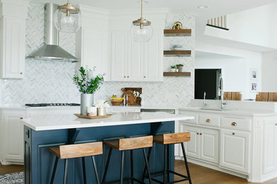 Example of a large transitional u-shaped medium tone wood floor and brown floor eat-in kitchen design in Minneapolis with an undermount sink, shaker cabinets, white cabinets, quartz countertops, white backsplash, marble backsplash, stainless steel appliances, an island and white countertops
