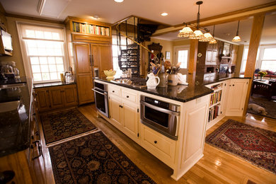 Large traditional u-shaped kitchen in St Louis with a submerged sink, light wood cabinets, granite worktops, light hardwood flooring and an island.
