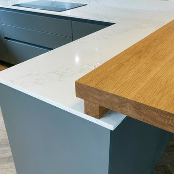 Thin profile marble quartz counter, chunky oak breakfast bar