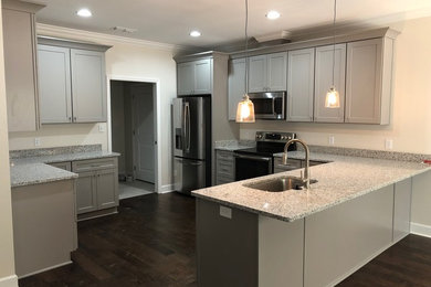 Mid-sized minimalist u-shaped dark wood floor and brown floor kitchen photo in Atlanta with a single-bowl sink, shaker cabinets, gray cabinets, granite countertops, stainless steel appliances, a peninsula and gray countertops