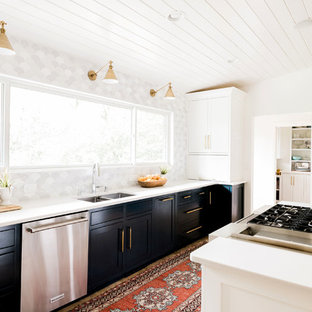 Midcentury kitchen in Atlanta with a double-bowl sink, shaker cabinets, black cabinets, multi-coloured splashback, stainless steel appliances, with island and white benchtop.