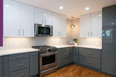Large minimalist u-shaped medium tone wood floor and brown floor eat-in kitchen photo in Other with an undermount sink, flat-panel cabinets, gray cabinets, quartz countertops, white backsplash, glass tile backsplash, stainless steel appliances, a peninsula and white countertops