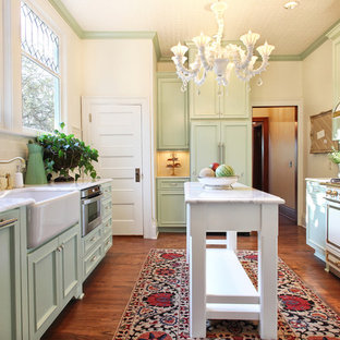 Ispirazione per una cucina parallela vittoriana chiusa con lavello stile country, ante verdi, ante con riquadro incassato, top in quarzo composito, paraspruzzi beige, paraspruzzi con piastrelle in ceramica, pavimento in legno massello medio e isola
