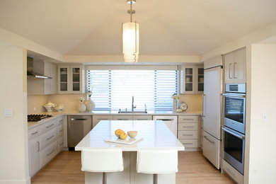 Kitchen in San Francisco with raised-panel cabinets, engineered stone countertops and white worktops.