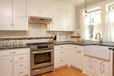ミネアポリスにあるトラディショナルスタイルのおしゃれな独立型キッチン (エプロンフロントシンク、シェーカースタイル扉のキャビネット、白いキャビネット、マルチカラーのキッチンパネル、シルバーの調理設備) の写真
