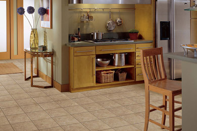 Example of a mid-sized single-wall ceramic tile eat-in kitchen design in New York with flat-panel cabinets, light wood cabinets, stainless steel appliances and an island