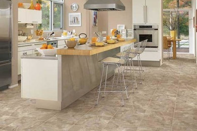 Inspiration for a large contemporary l-shaped porcelain tile and beige floor enclosed kitchen remodel in Milwaukee with an undermount sink, flat-panel cabinets, white cabinets, wood countertops, stainless steel appliances and an island
