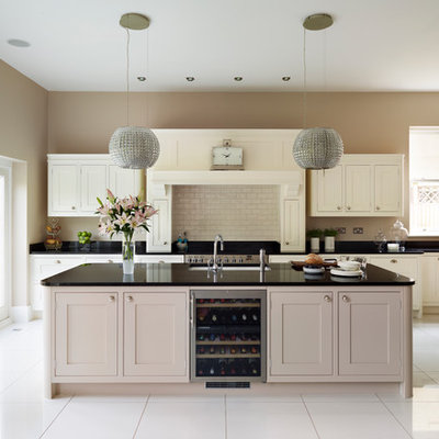 Large transitional single-wall open concept kitchen photo in London with shaker cabinets, beige cabinets, granite countertops, beige backsplash, subway tile backsplash, stainless steel appliances, an island and an undermount sink
