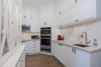 Example of a large transitional l-shaped medium tone wood floor and brown floor eat-in kitchen design in San Diego with a double-bowl sink, raised-panel cabinets, white cabinets, quartzite countertops, multicolored backsplash, porcelain backsplash, stainless steel appliances, an island and multicolored countertops