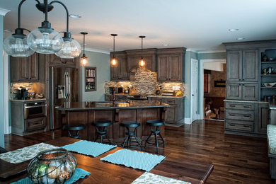 Inspiration for a large transitional l-shaped dark wood floor eat-in kitchen remodel in Charlotte with an undermount sink, stainless steel appliances, multicolored backsplash, matchstick tile backsplash, recessed-panel cabinets, dark wood cabinets, an island and granite countertops