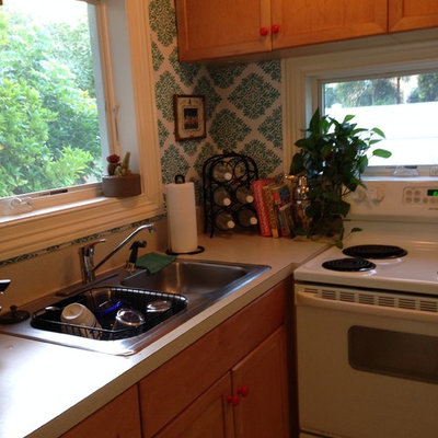 Example of a beach style l-shaped eat-in kitchen design in Miami with laminate countertops and white appliances