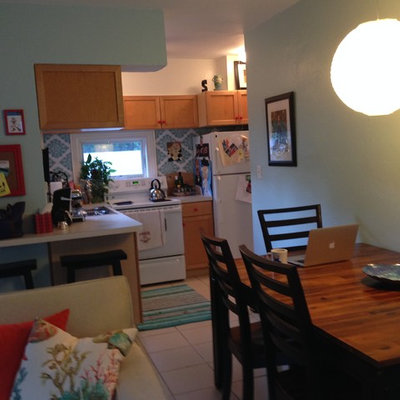 Example of a beach style l-shaped eat-in kitchen design in Miami with laminate countertops and white appliances