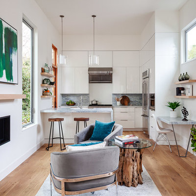 Open concept kitchen - small contemporary galley medium tone wood floor and brown floor open concept kitchen idea in San Francisco with an undermount sink, flat-panel cabinets, white cabinets, gray backsplash, stainless steel appliances, a peninsula and gray countertops