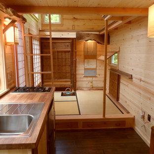 Immagine di una piccola cucina etnica con lavello da incasso, top in legno, ante lisce, ante in legno scuro, elettrodomestici in acciaio inossidabile, parquet scuro, nessuna isola e pavimento marrone