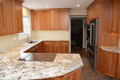 Inspiration for a mid-sized transitional u-shaped multicolored floor enclosed kitchen remodel in DC Metro with a single-bowl sink, raised-panel cabinets, medium tone wood cabinets, granite countertops, glass tile backsplash, stainless steel appliances and a peninsula