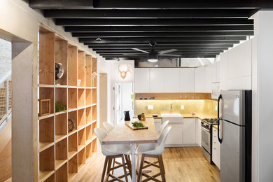 Eat-in kitchen - mid-sized scandinavian l-shaped eat-in kitchen idea in New York with flat-panel cabinets, white cabinets, yellow backsplash, an island and yellow countertops
