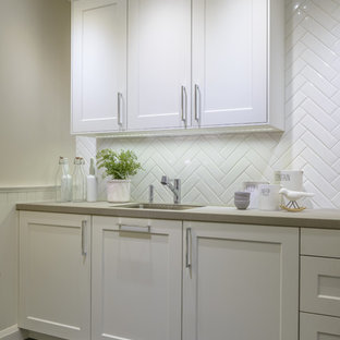 Inspiration for a mid-sized transitional l-shaped eat-in kitchen in Toronto with shaker cabinets, white cabinets, quartzite benchtops, white splashback, ceramic splashback, stainless steel appliances, slate floors, no island, an undermount sink and blue floor.