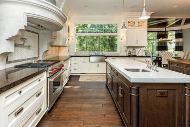 This is an example of a traditional kitchen/diner in Other with engineered stone countertops and multiple islands.