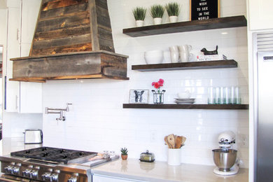 Example of a large transitional porcelain tile and brown floor kitchen design in Phoenix with white backsplash, subway tile backsplash, stainless steel appliances and an island