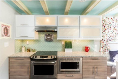 Mid-sized transitional eat-in kitchen photo in Tampa with flat-panel cabinets, dark wood cabinets, granite countertops, green backsplash and glass tile backsplash