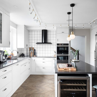 Idéer för stora skandinaviska svart kök, med vita skåp, bänkskiva i koppar, vitt stänkskydd, stänkskydd i keramik, rostfria vitvaror, en köksö, brunt golv, en undermonterad diskho och mellanmörkt trägolv