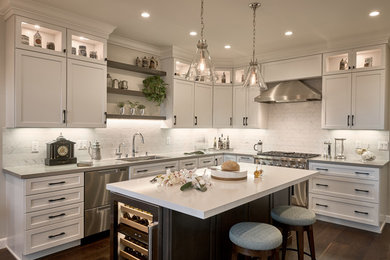 Transitional medium tone wood floor and brown floor kitchen photo in San Francisco with a drop-in sink, raised-panel cabinets, white cabinets, quartz countertops, white backsplash, porcelain backsplash, stainless steel appliances, an island and gray countertops