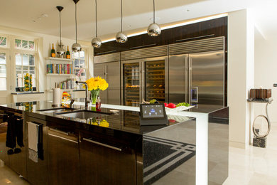 This is an example of a medium sized contemporary kitchen in London with a double-bowl sink, flat-panel cabinets, an island and beige floors.