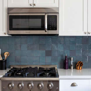 Inspiration for a mid-sized transitional u-shaped eat-in kitchen in Los Angeles with a drop-in sink, shaker cabinets, white cabinets, copper benchtops, blue splashback, ceramic splashback, stainless steel appliances, dark hardwood floors, with island, brown floor and white benchtop.