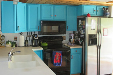 Eat-in kitchen - mid-sized southwestern l-shaped medium tone wood floor and red floor eat-in kitchen idea in Denver with a double-bowl sink, raised-panel cabinets, turquoise cabinets, solid surface countertops, white backsplash, stainless steel appliances, an island and white countertops