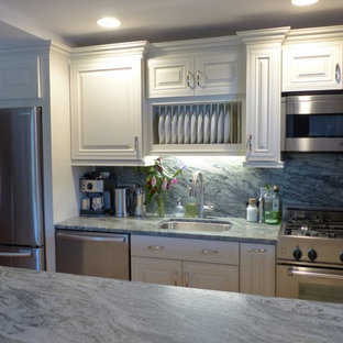 Diseño de cocina comedor de galera, tradicional, pequeña, con fregadero bajoencimera, armarios con paneles con relieve, puertas de armario blancas, encimera de granito, salpicadero rosa, salpicadero de losas de piedra, electrodomésticos de acero inoxidable, suelo de madera clara, una isla y suelo amarillo