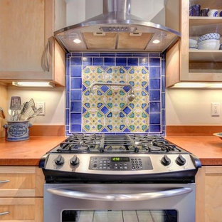 Foto de cocina lineal, mediterránea, de tamaño medio, cerrada, con armarios estilo shaker, puertas de armario de madera clara, encimera de cuarzo compacto, salpicadero multicolor, salpicadero de azulejos de cemento, electrodomésticos de acero inoxidable, suelo de baldosas de porcelana, península, suelo gris y encimeras naranjas