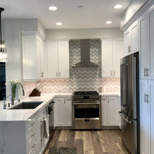 Small modern u-shaped eat-in kitchen in Los Angeles with a single-bowl sink, recessed-panel cabinets, white cabinets, quartz benchtops, mosaic tile splashback, stainless steel appliances, vinyl floors, a peninsula and white benchtop.