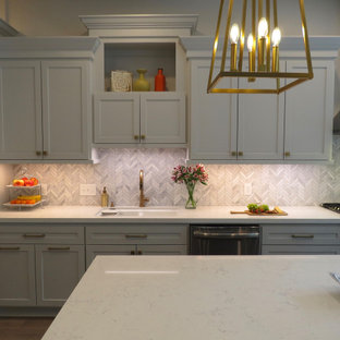 Inspiration for a mid-sized transitional l-shaped eat-in kitchen in Houston with shaker cabinets, grey cabinets, quartz benchtops, white splashback, marble splashback, stainless steel appliances, vinyl floors, with island, beige floor, white benchtop and an undermount sink.