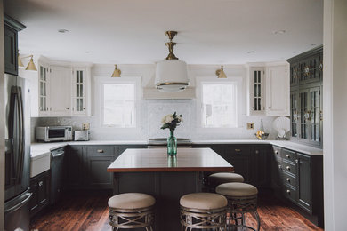 Large ornate u-shaped dark wood floor and brown floor eat-in kitchen photo in Boston with a farmhouse sink, beaded inset cabinets, gray cabinets, quartz countertops, white backsplash, ceramic backsplash, stainless steel appliances and an island