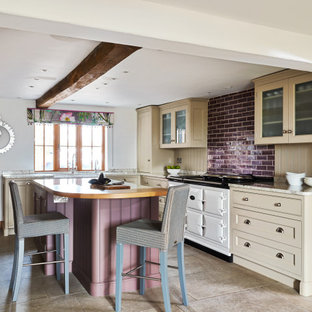 Inspiration for a farmhouse u-shaped enclosed kitchen in Cheshire with a belfast sink, shaker cabinets, beige cabinets, wood worktops, beige splashback, white appliances, an island, beige floors, brown worktops and exposed beams.