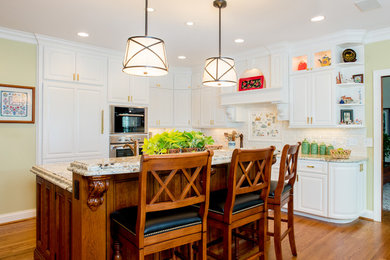 Example of a large classic l-shaped medium tone wood floor and brown floor eat-in kitchen design in Cincinnati with a double-bowl sink, raised-panel cabinets, white cabinets, granite countertops, white backsplash, stainless steel appliances, an island and porcelain backsplash