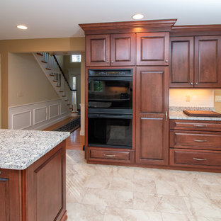 Inspiration for a large traditional galley eat-in kitchen in Manchester with a single-bowl sink, raised-panel cabinets, dark wood cabinets, granite benchtops, white splashback, subway tile splashback, black appliances, porcelain floors, with island, beige floor and yellow benchtop.