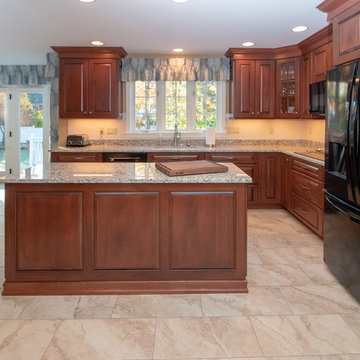 Traditional Cognac/Antique Black Cherry stain finishes with Crema Pearl Granite