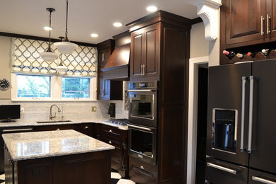 Example of a mid-sized classic l-shaped marble floor enclosed kitchen design in Other with an undermount sink, raised-panel cabinets, dark wood cabinets, quartz countertops, white backsplash, mosaic tile backsplash, stainless steel appliances and an island