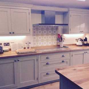 Design ideas for a mid-sized traditional single-wall eat-in kitchen in Surrey with a drop-in sink, beaded inset cabinets, beige cabinets, wood benchtops, multi-coloured splashback, porcelain splashback, stainless steel appliances, light hardwood floors and with island.