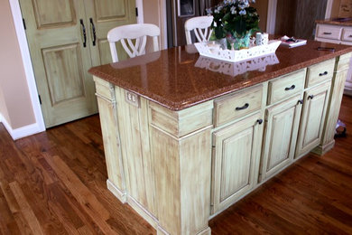 Mid-sized elegant l-shaped medium tone wood floor eat-in kitchen photo in Indianapolis with raised-panel cabinets, green cabinets, granite countertops, stainless steel appliances and an island