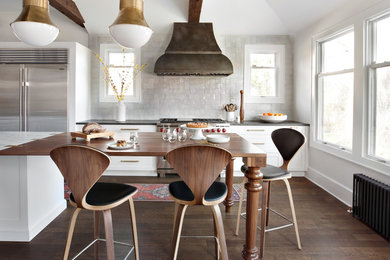 Eat-in kitchen - large eclectic galley dark wood floor and brown floor eat-in kitchen idea in New York with an undermount sink, recessed-panel cabinets, white cabinets, marble countertops, white backsplash, ceramic backsplash, stainless steel appliances, an island and white countertops