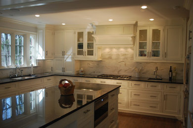 Eat-in kitchen - traditional u-shaped eat-in kitchen idea in New York with an undermount sink, beaded inset cabinets, white cabinets, granite countertops, beige backsplash, stone tile backsplash and stainless steel appliances