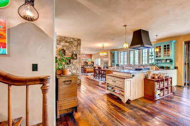 Klassisk inredning av ett kök, med en rustik diskho, luckor med profilerade fronter, skåp i slitet trä, beige stänkskydd, rostfria vitvaror och brunt golv