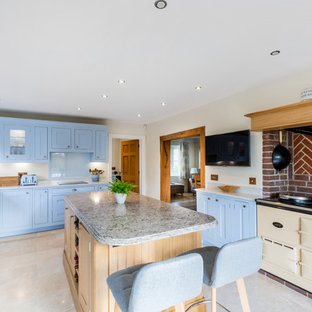 Inspiration for a classic u-shaped enclosed kitchen in Surrey with shaker cabinets, blue cabinets, quartz worktops, blue splashback, an island, a belfast sink, glass sheet splashback, coloured appliances, beige floors and grey worktops.