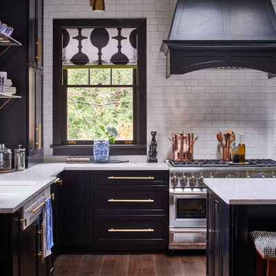 Mid-sized transitional l-shaped medium tone wood floor and brown floor kitchen photo in Raleigh with shaker cabinets, white backsplash, subway tile backsplash, stainless steel appliances, an island, an undermount sink and quartz countertops