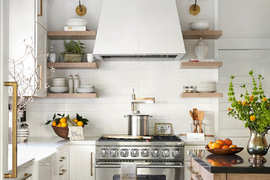 Example of a transitional l-shaped ceramic tile kitchen design in San Francisco with white backsplash, ceramic backsplash, an island, a farmhouse sink, shaker cabinets, white cabinets and stainless steel appliances