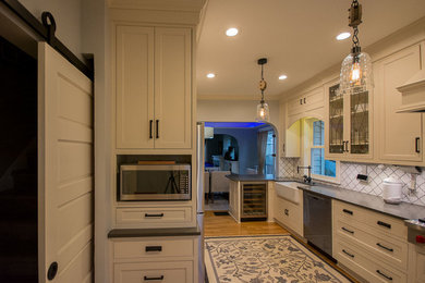 Foto på ett mellanstort vintage kök, med en rustik diskho, luckor med profilerade fronter, vita skåp, bänkskiva i kvarts, vitt stänkskydd, stänkskydd i keramik, rostfria vitvaror, ljust trägolv och en halv köksö